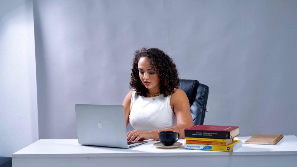 Mayara Tavares ao computador, preparando um atendimento
